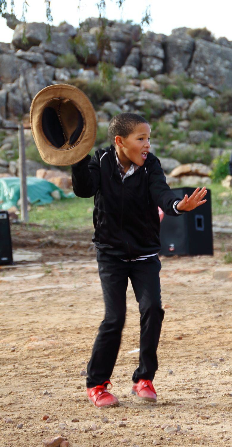 A young riel dancer of Die Nuwe Graskoue Trappers holding a hat in his hand
