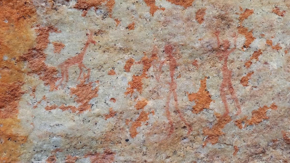 San rock painting of figures with a bow and an antelope in red ochre