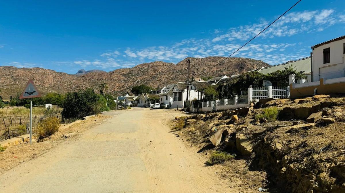 The gravel main street of Wupperthal lined with whitewashed thatched cottages