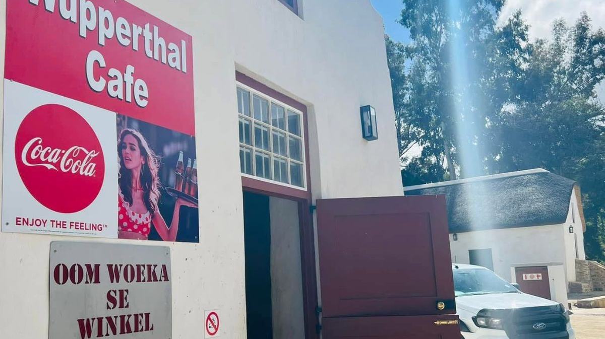 The Wupperthal Cafe, also signed Oom Woeka se Winkel, whitewashed with a red-framed doorway